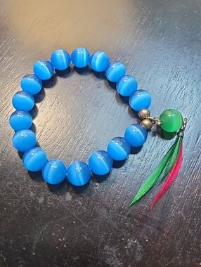 Blue Beaded Stretch Bracelet with Green Accent and Feather Charm
